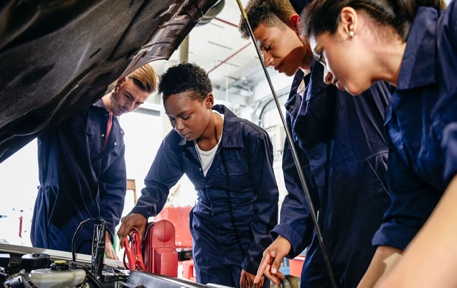 Students working fixing a car