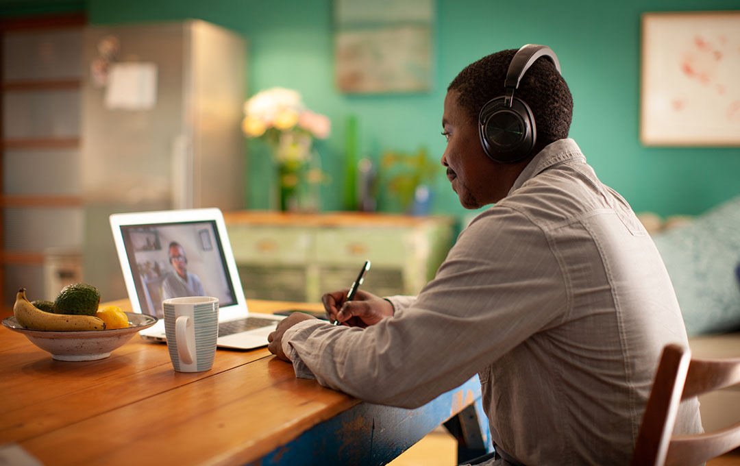 student listening to a lecture on his laptop