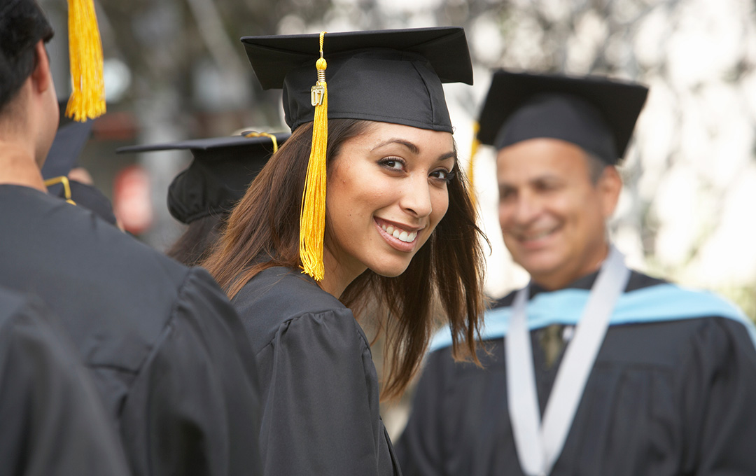 woman smiling in a graduation gown