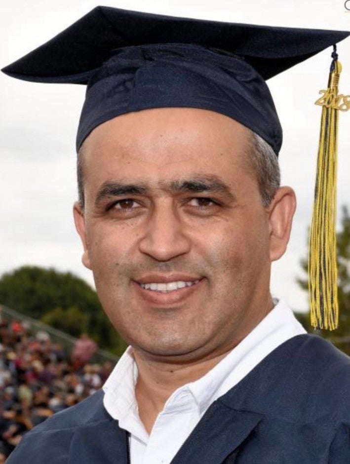 Aref in a cap and gown at graduation