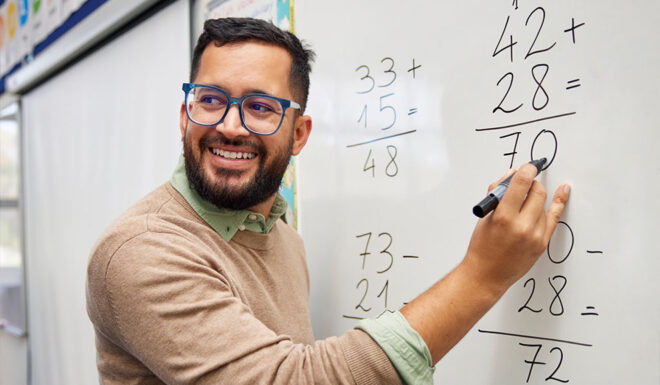 Teacher writing on whiteboard
